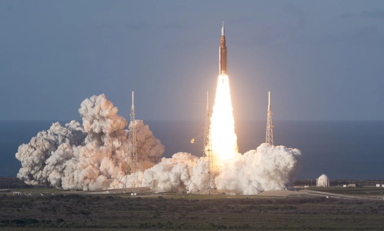 The Artemis II rocket blasts off from Kennedy Space Center leaving behind a plume of smoke.